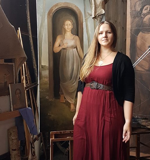 Bilde av Elisabeth Berggren Hansen på gården til Odd Nerdrum i 2018 (Stavern, Norway)foran noen av hennes påbegynte malerier